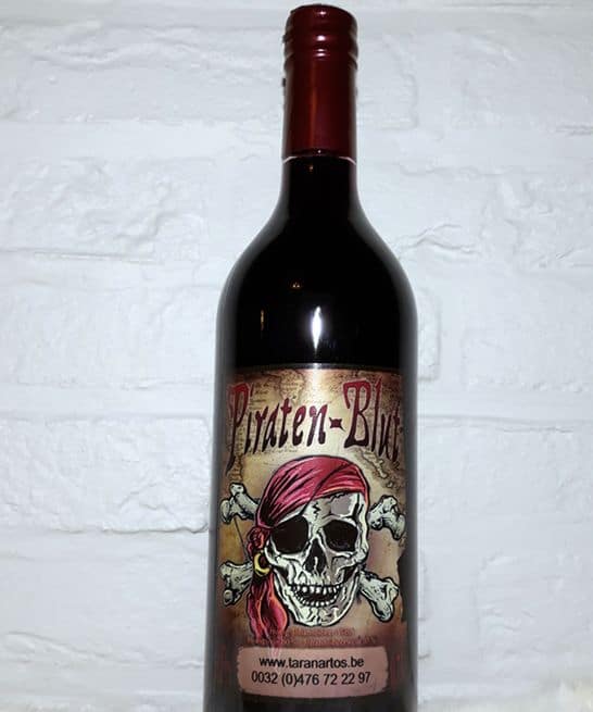 Een fles rode wijn met een opvallend label van een skull met een roze bandana, ideaal voor wijnliefhebbers en verzamelaars.